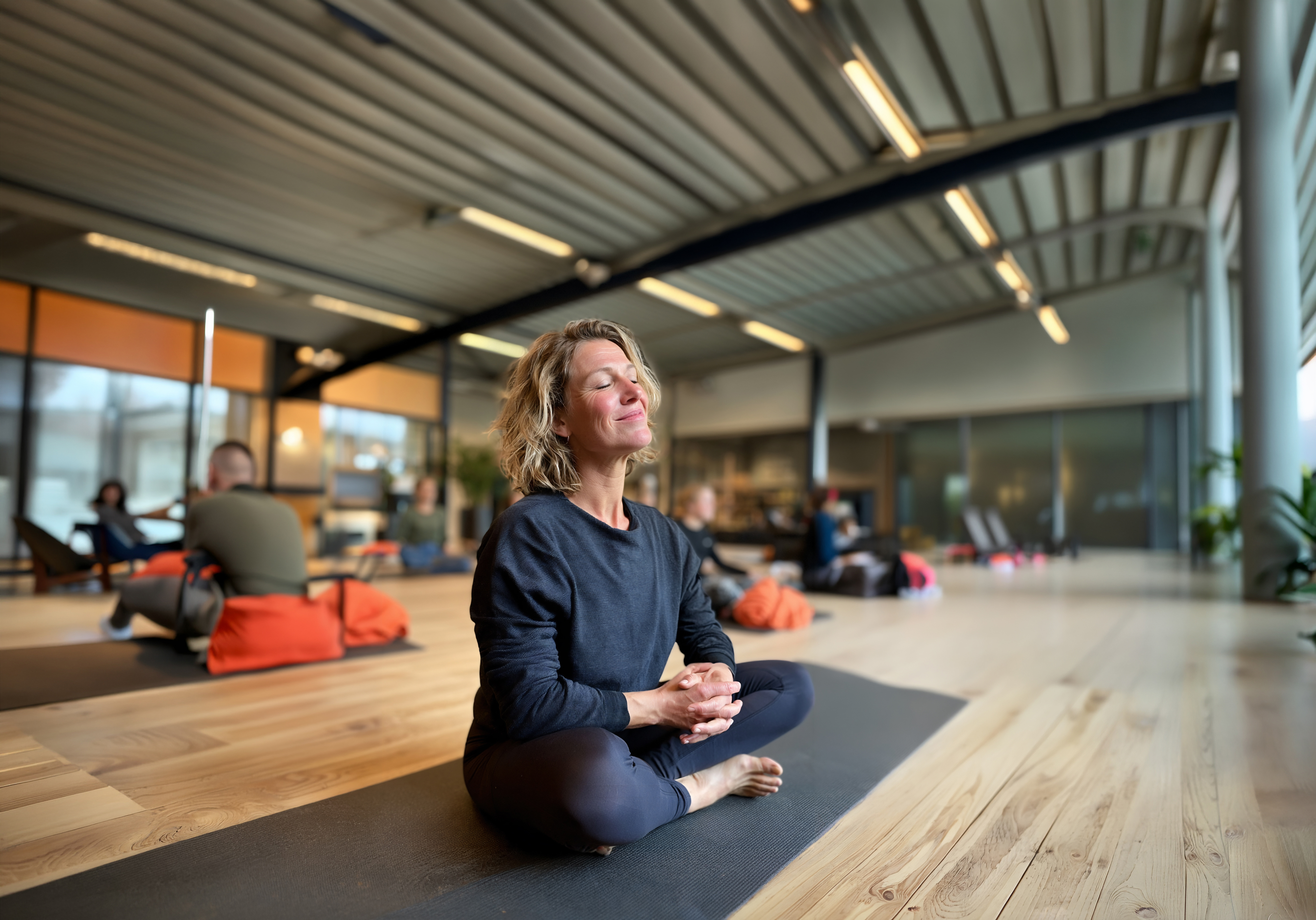 Vrouw zit rustig op een matje yoga te doen