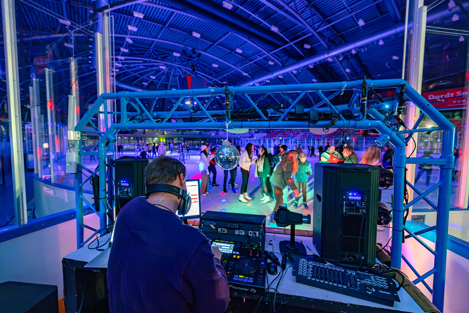 DJ zet de nieuwste hits op tijdens disco schaatsen