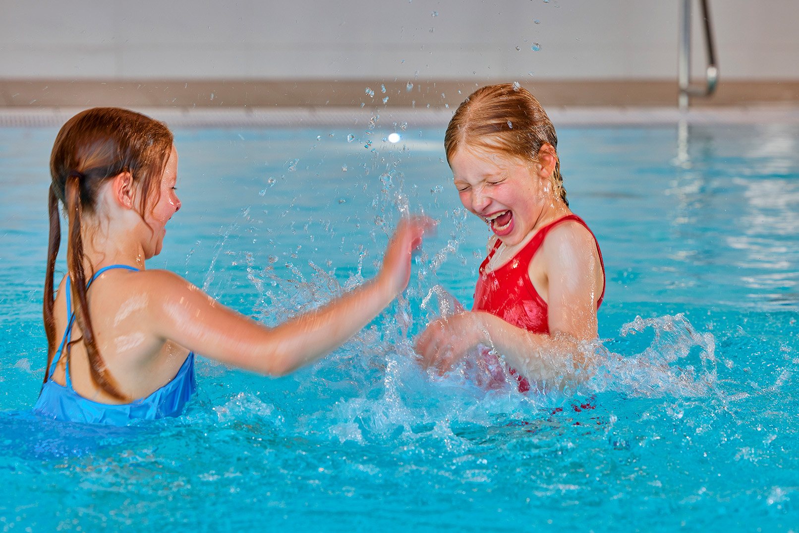 Twee meiden zijn zich aan het vermaken in het zwembad tijdens een kinderfeestje.