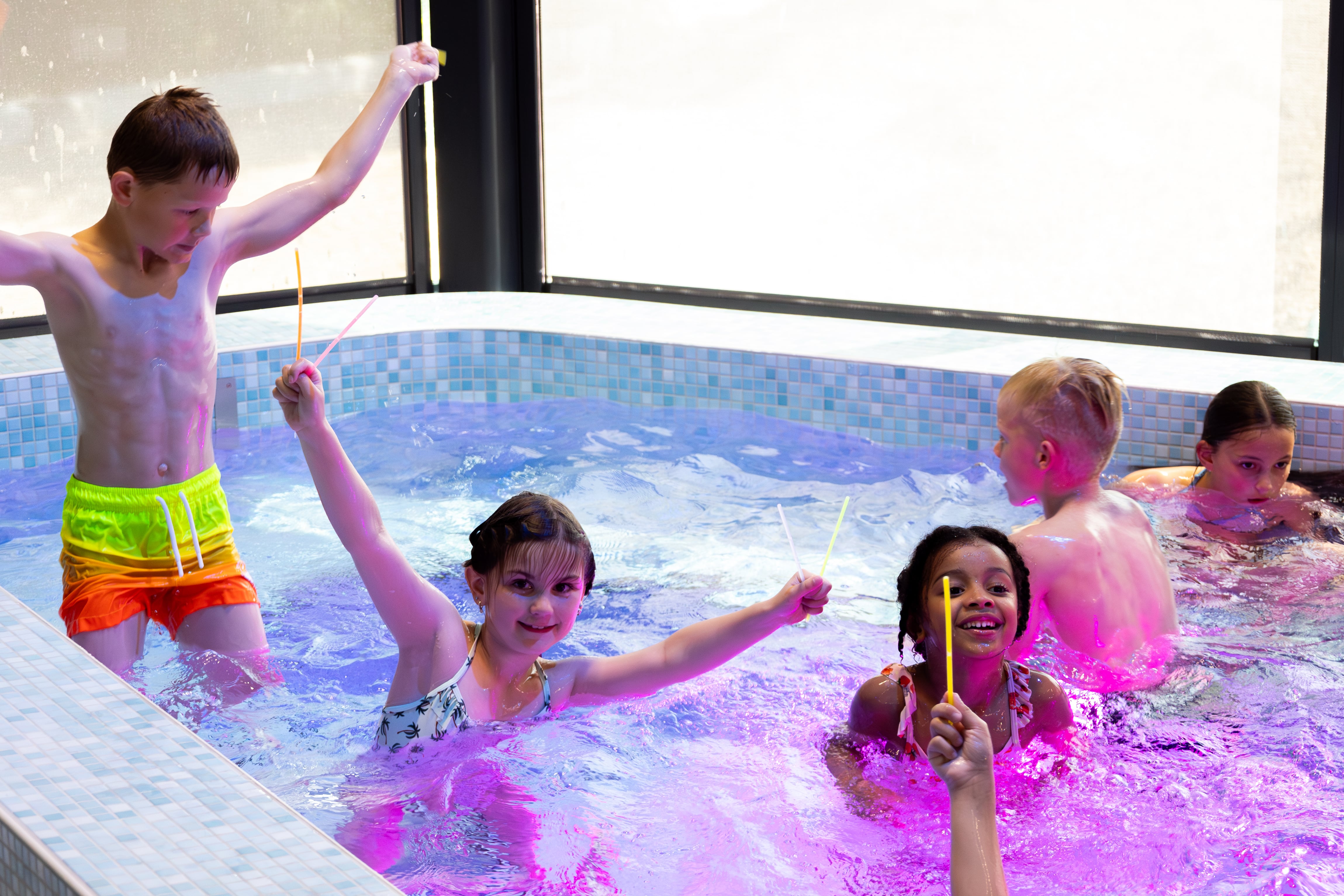 Kinderen zwemmen in het bubbelbad tijdens het zwemdiscofeestje bij Optisport.