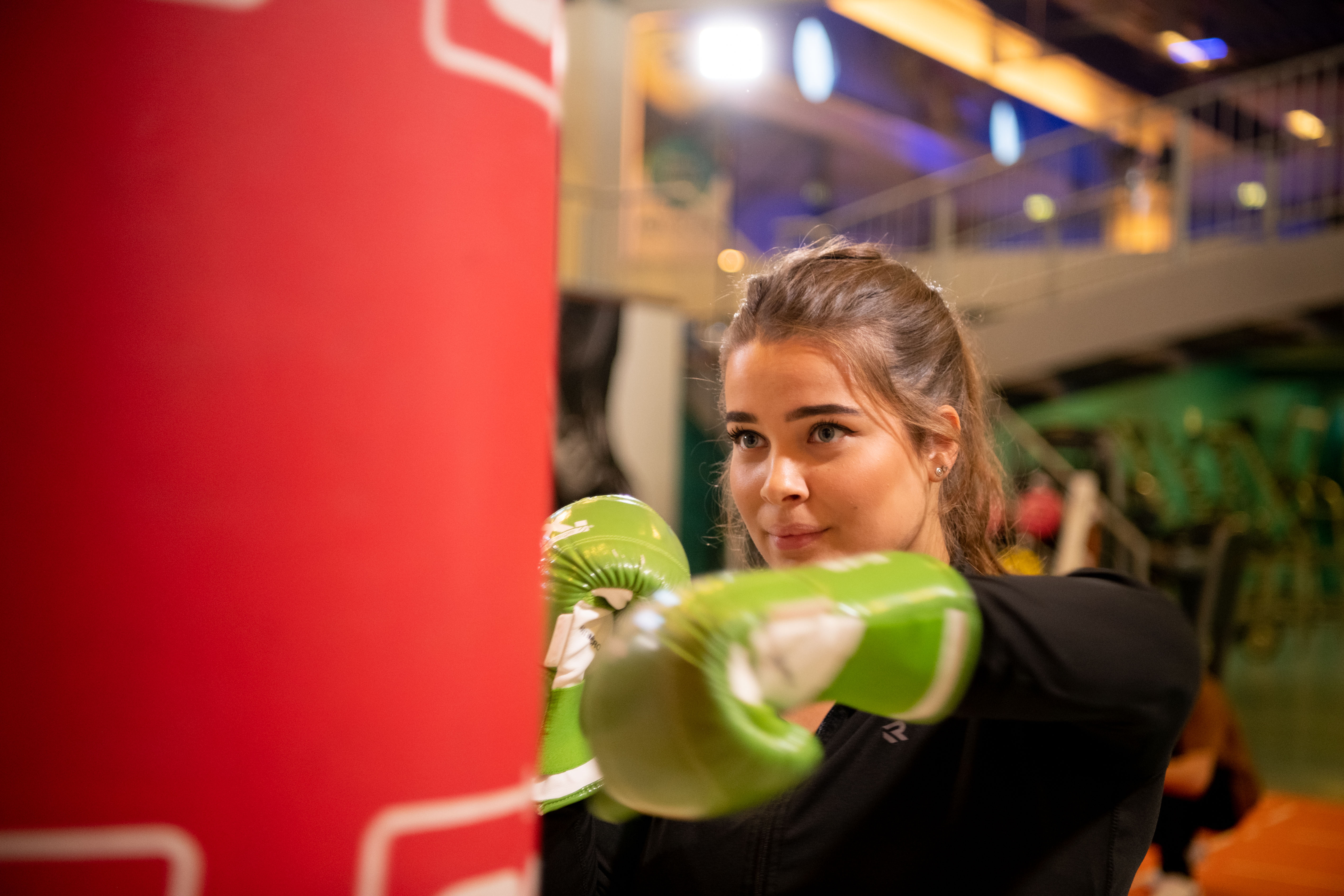 Boksen bij een locatie van HealthClub Optisport tijdens een groepsles. Een vrouw is aan het trainen met plezier.