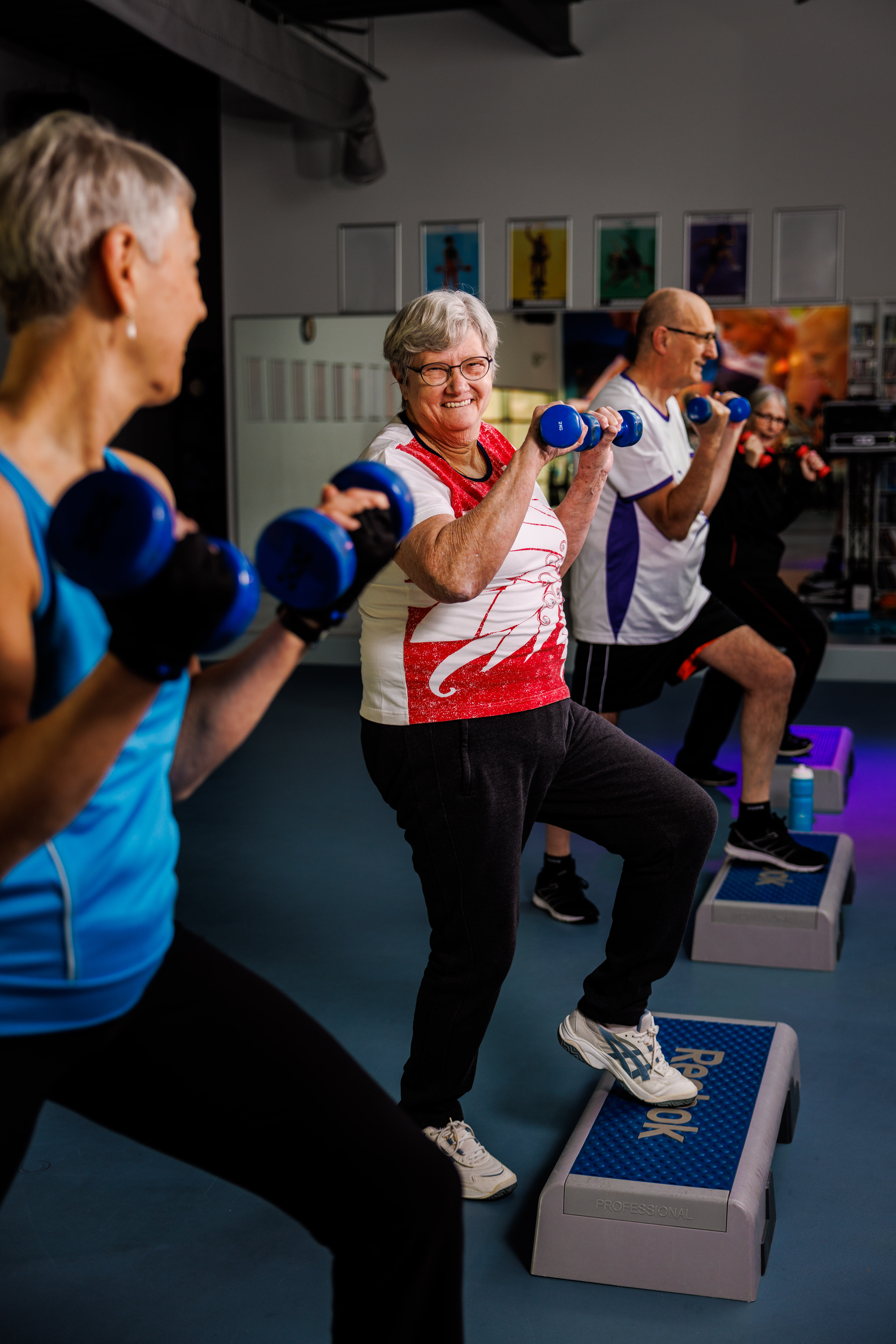 Verschillende mensen doen oefeningen bij Optisport tijdens een groepsles om fit te blijven.