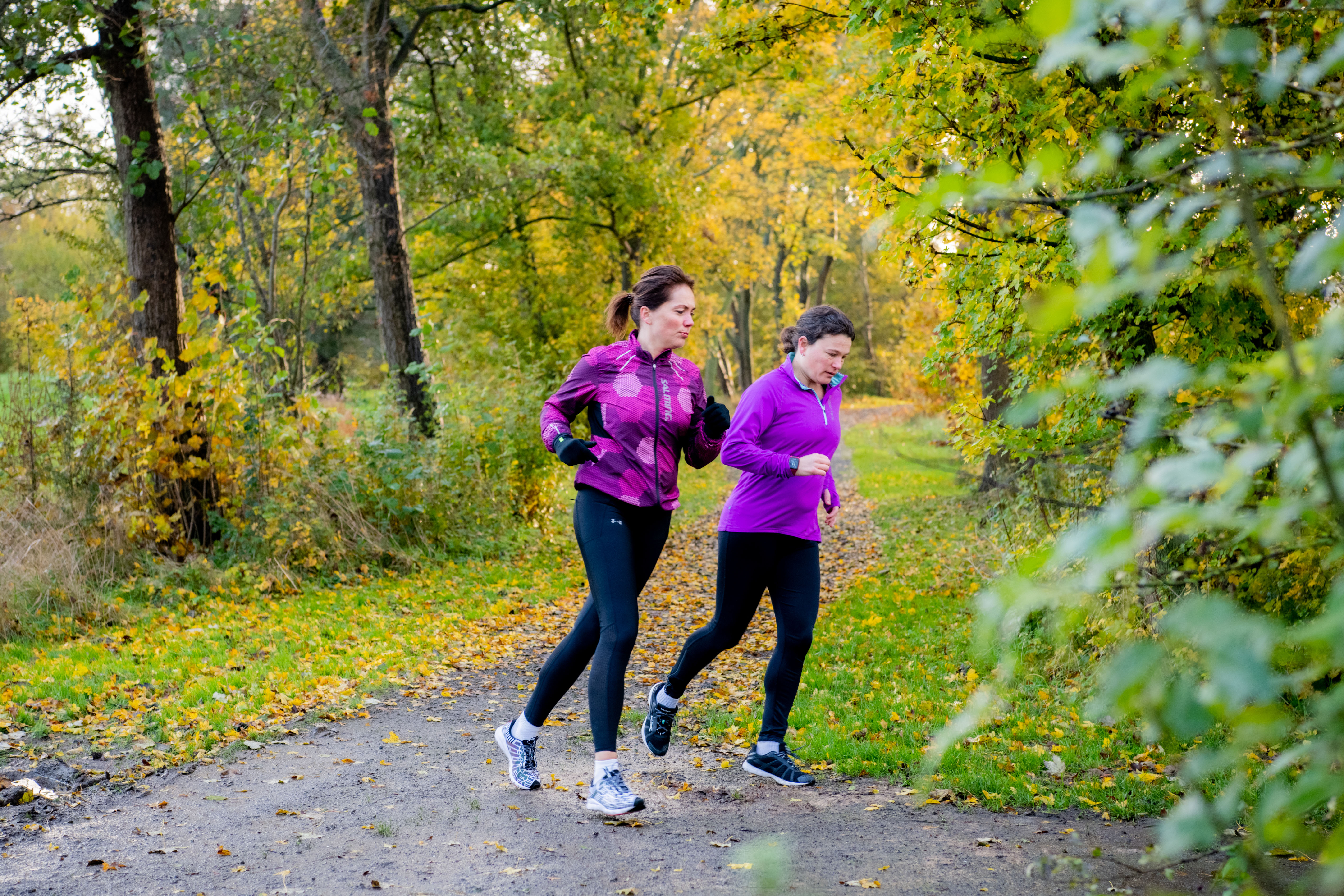 Twee vrouwen zijn aan het hardlopen door een bocht