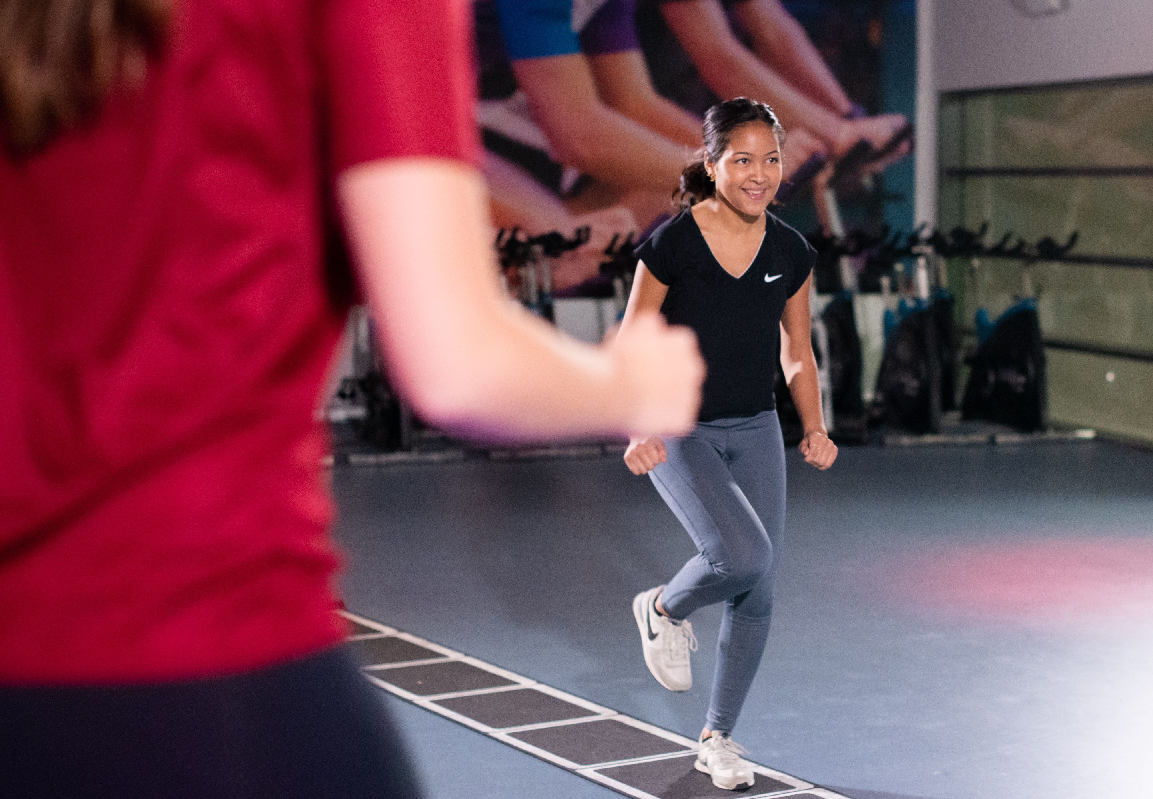 Meisje doet oefening in ladder die op de grond ligt met de jeugdfitness.