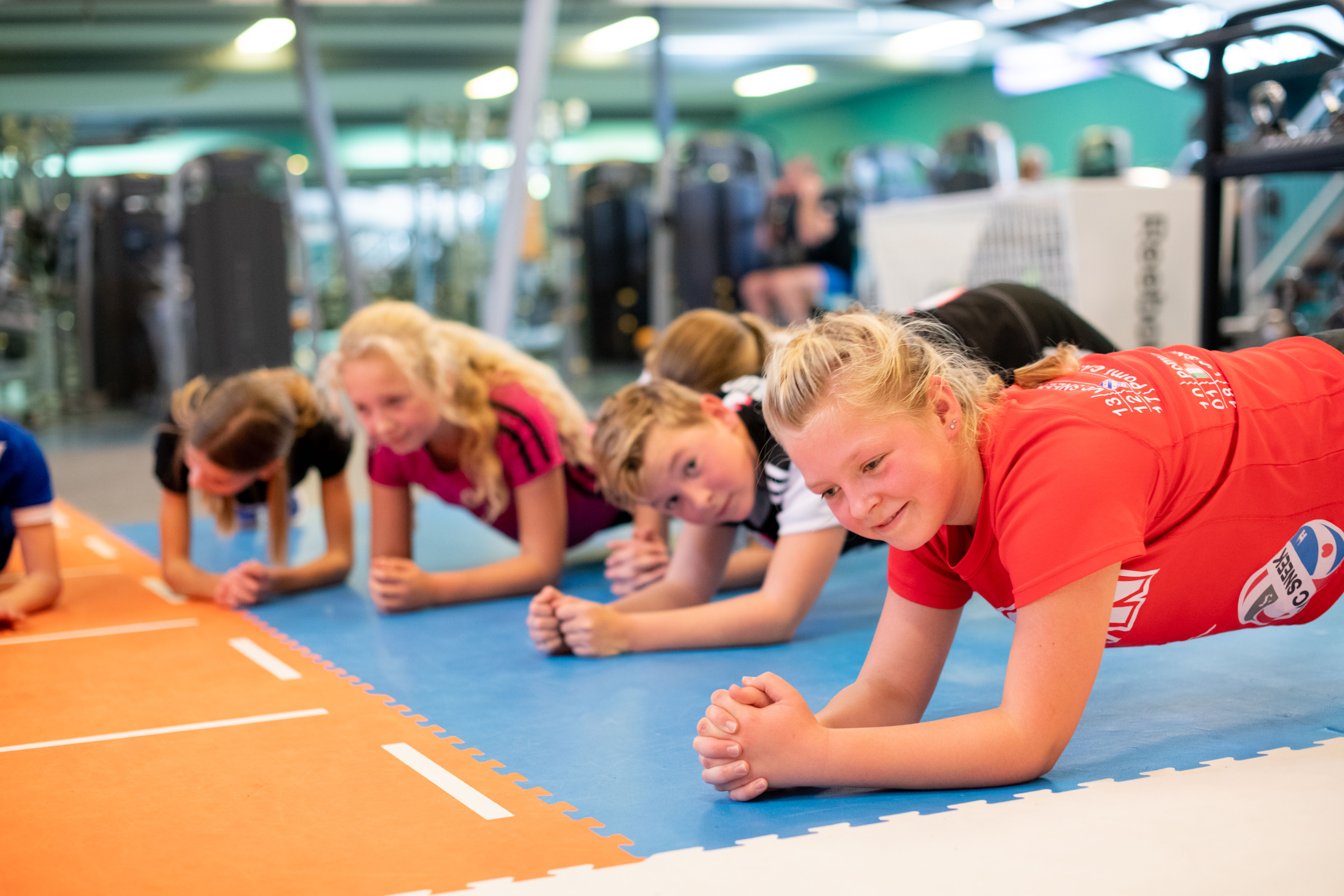 Kinderen zijn aan het boksen zonder lichamelijk contact. Tijdens een groepsles hebben de kinderen plezier onder begeleiding van een instructeur van Optisport.