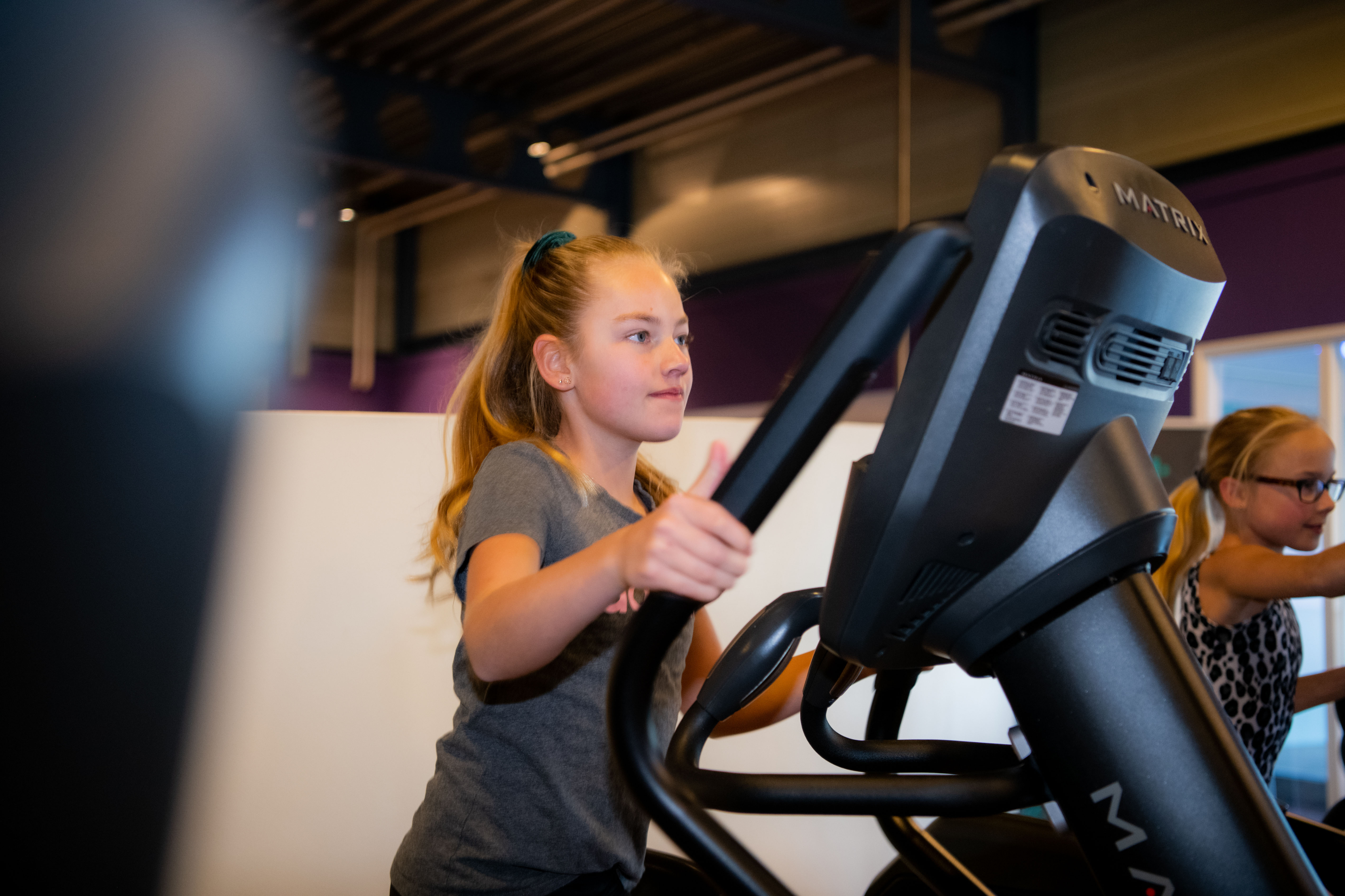 Groepsles fitness voor kinderen. De kinderen zijn oefeningen aan het doen onder begeleiding van een instructeur.