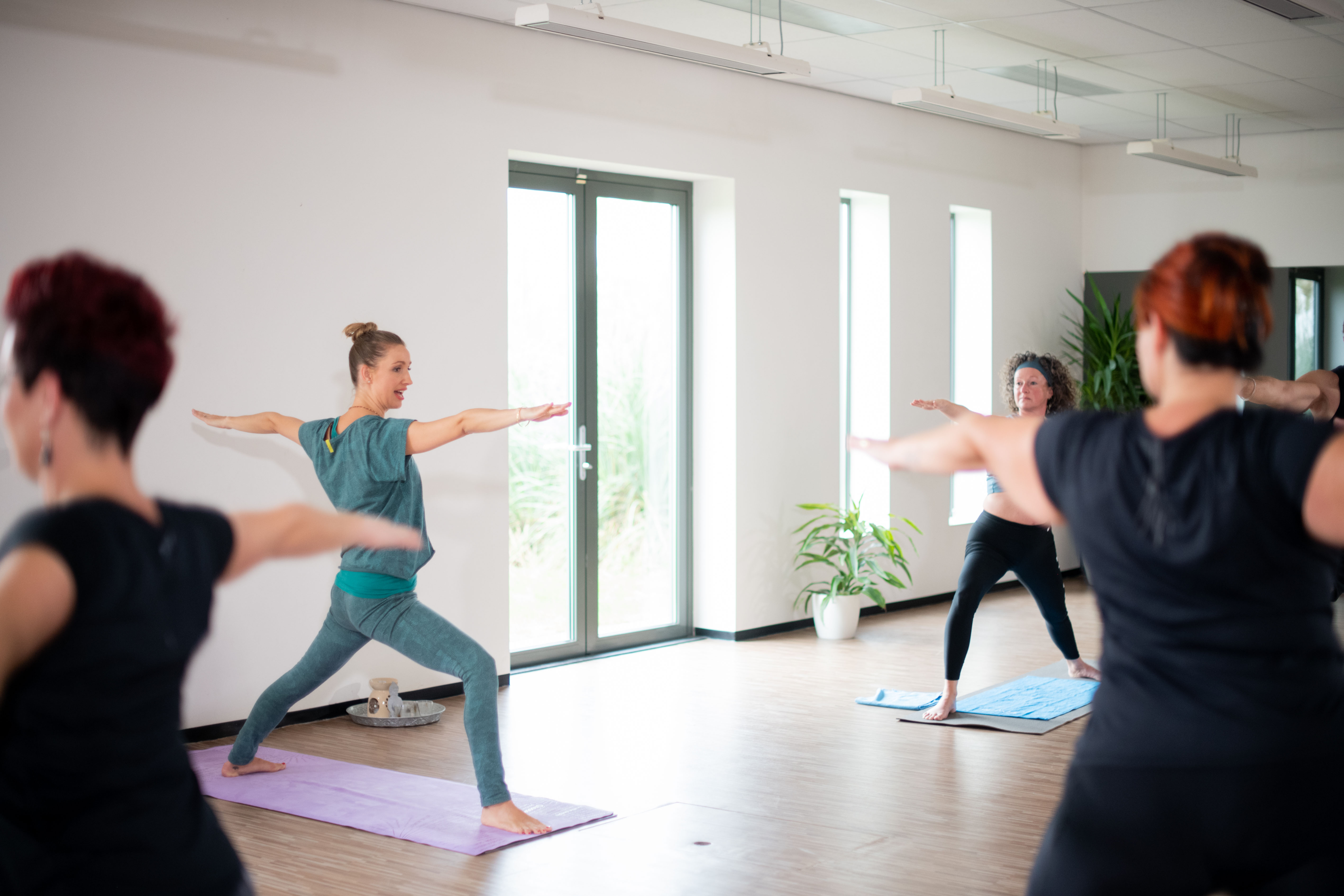 Vrouwen doen intensieve oefeningen tijdens de power yoga groepsles.