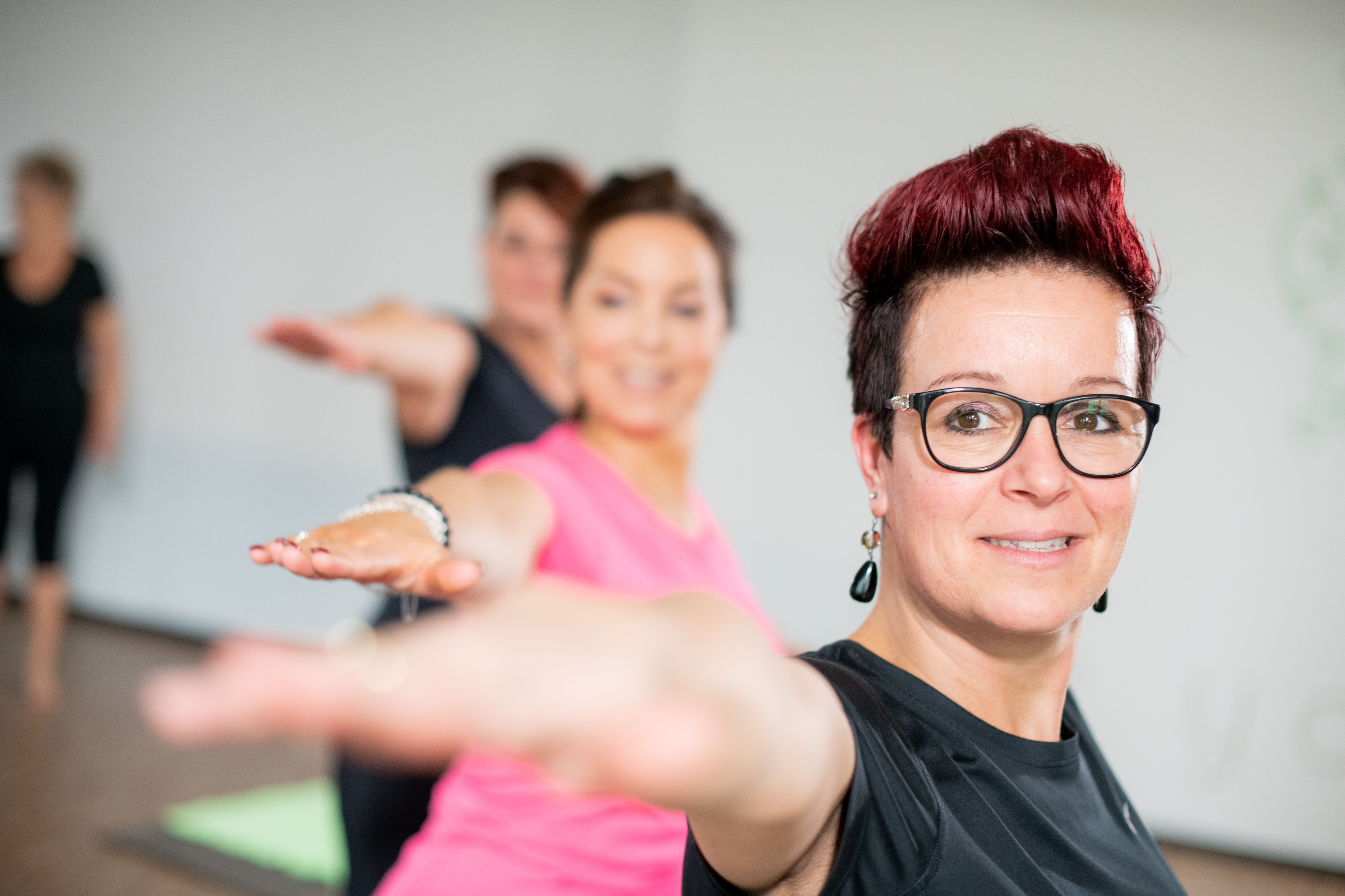 Vrouw is geconcentreerd yoga oefeningen aan het doen tijdens de groepsles.