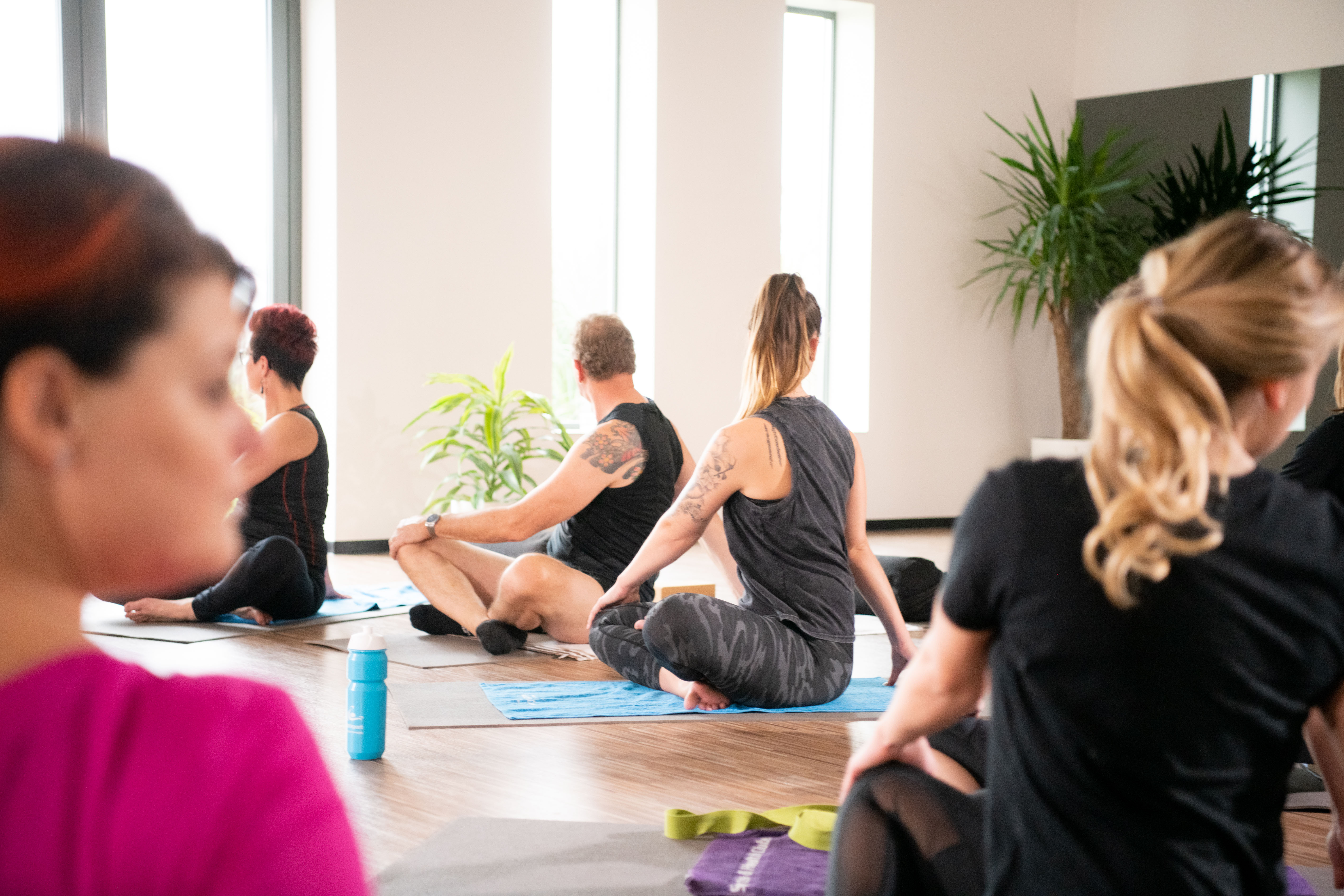 Restorative Yoga. Mensen zijn oefeningen aan het doen tijdens een groepsles onder begeleiding van een instructeur.