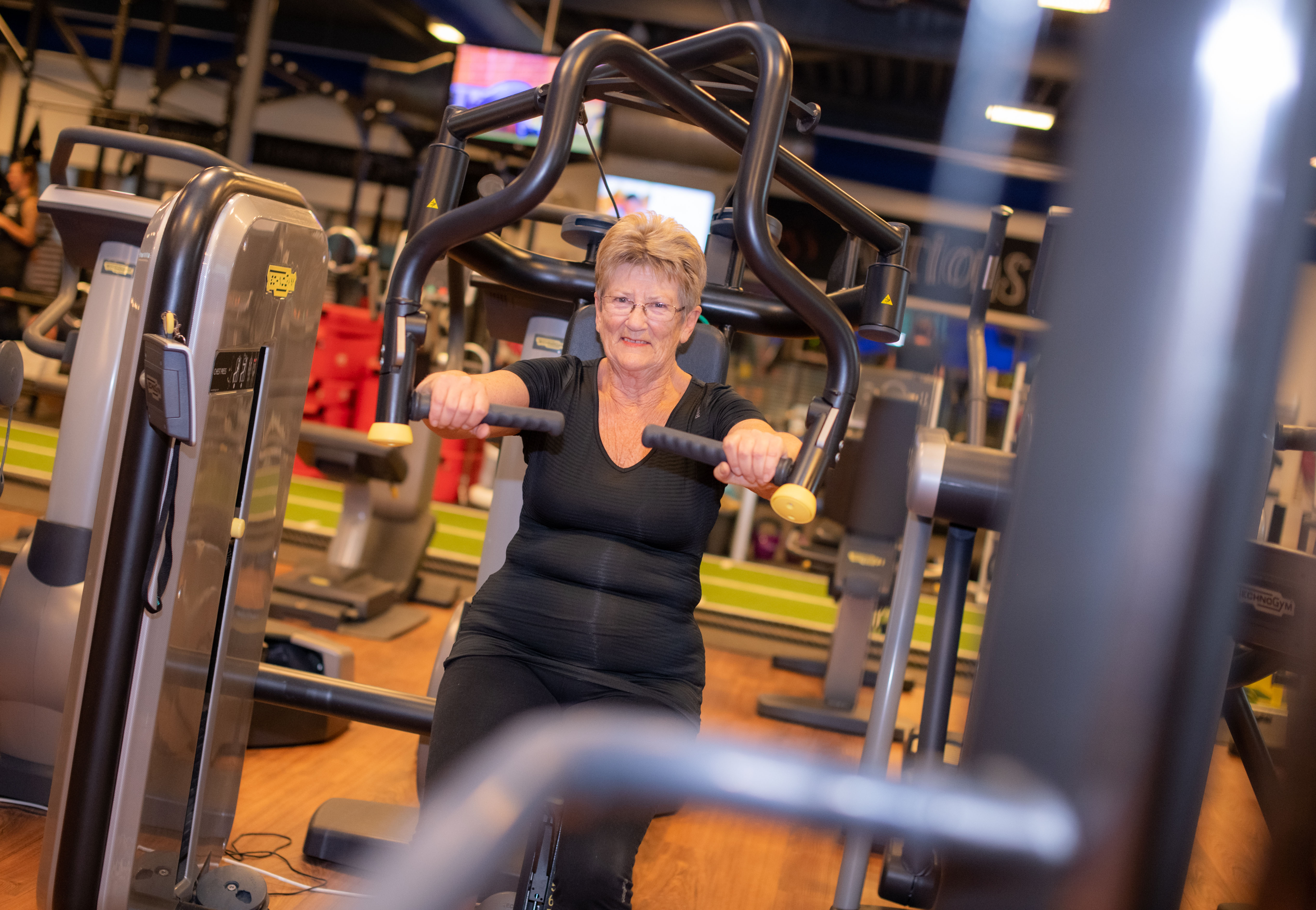 Een vrouw doet oefeningen in de sportschool om fit te blijven.