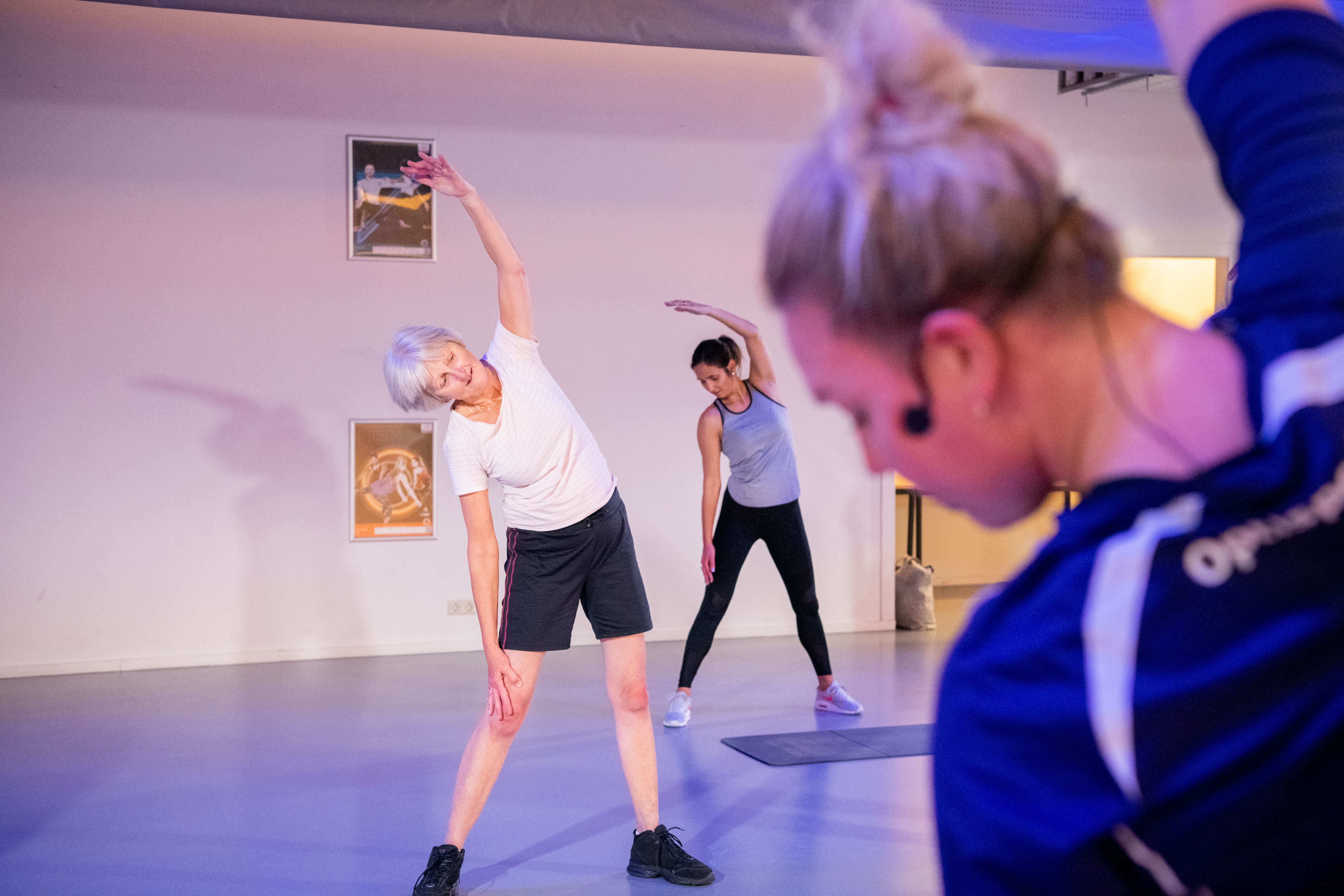 Groep mensen doen oefeningen bij de fitness.