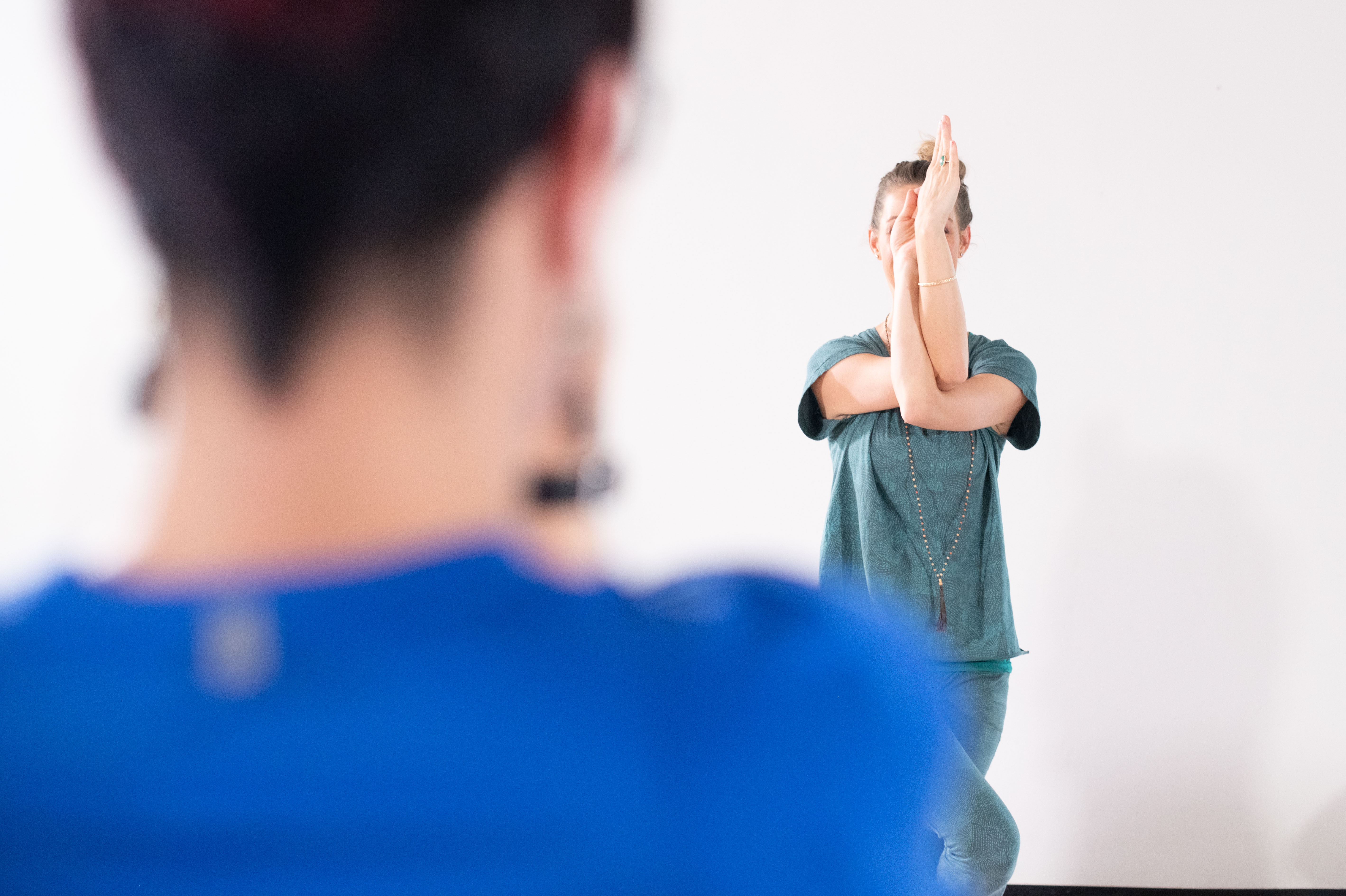 Een vrouw doet een oefening onder begeleiding van een instructeur.