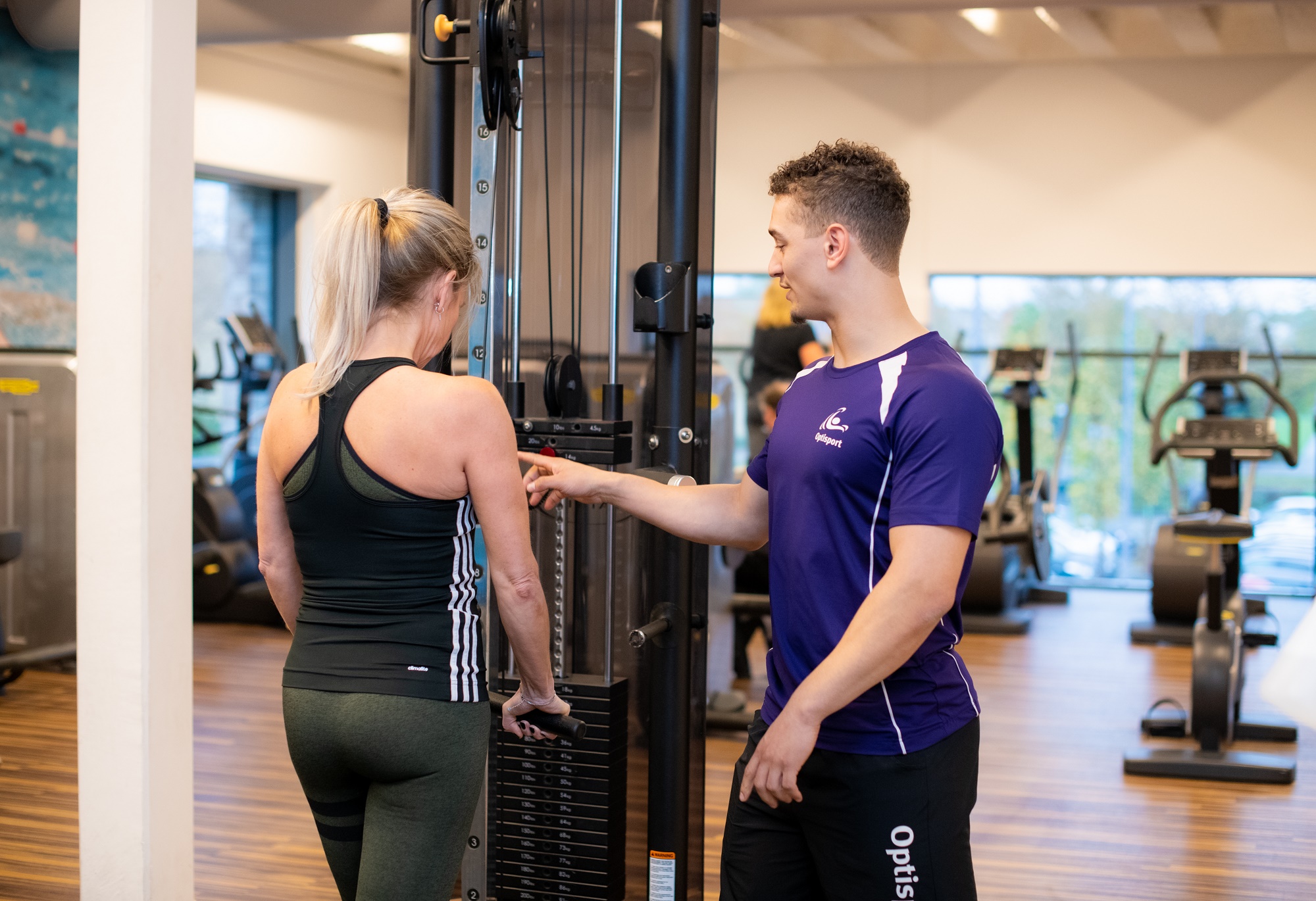 Warnsveld Leefstijlplan. Vrouw is aan het sporten met plezier en bereikt haar doelen met haar persoonlijke plan onder begeleiding van een instructeur.