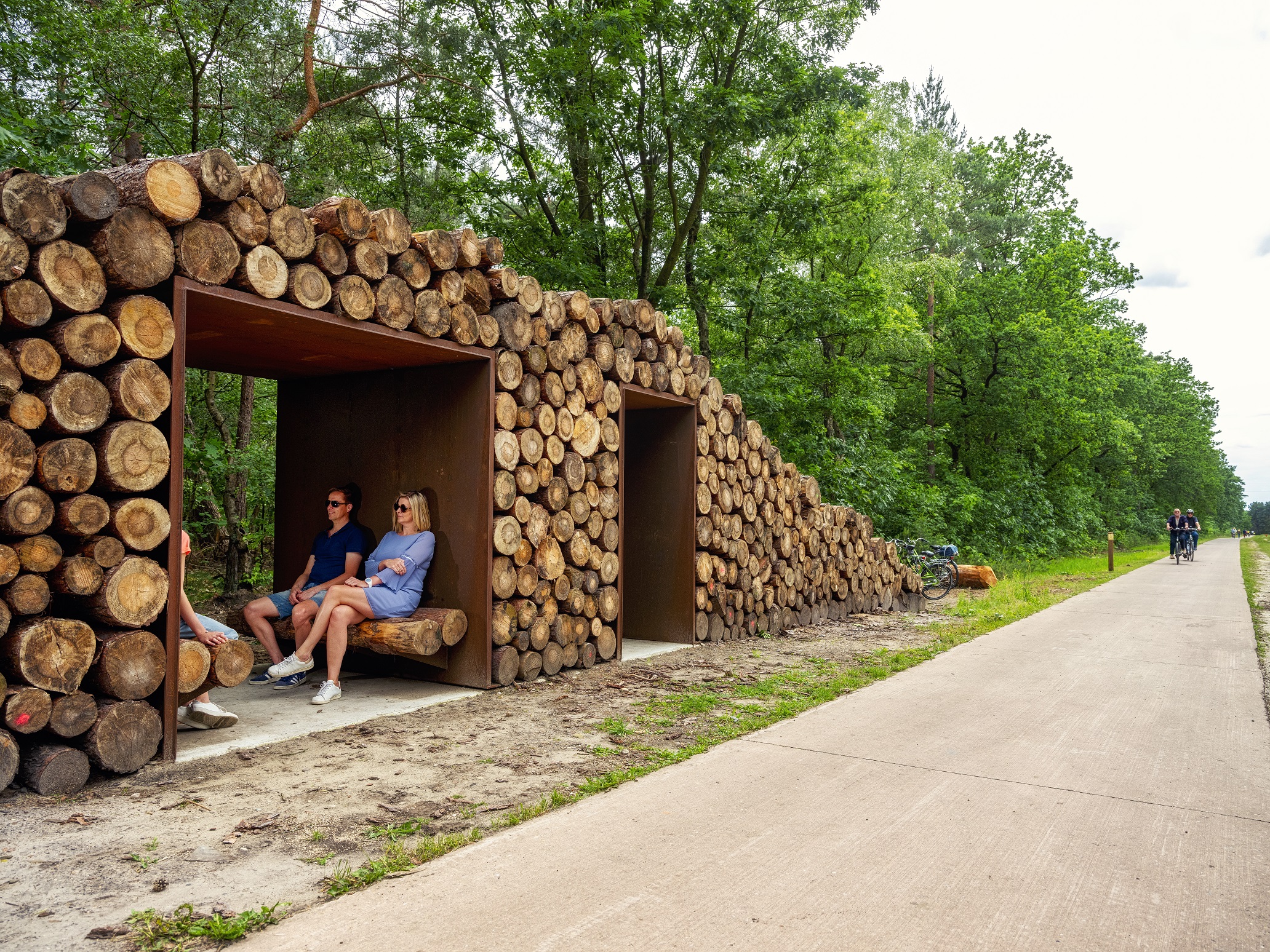 Blije fietsers fietsen door het bos in Lommel door middel van de fietsroute.