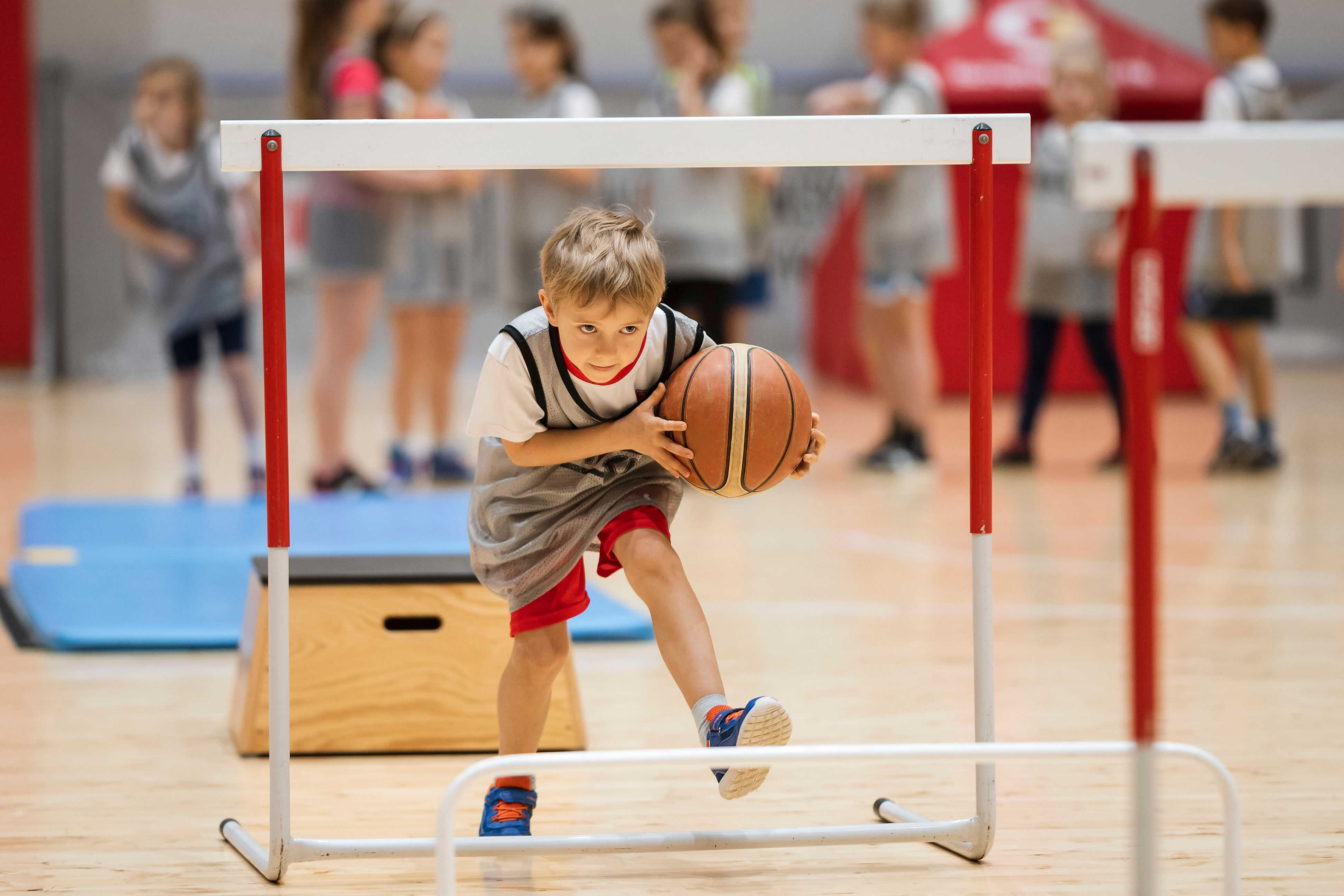 Zeskamp bij Optisport De Kreek. Een jongentje is met plezier oefeningen aan het doen in de sportzaal.