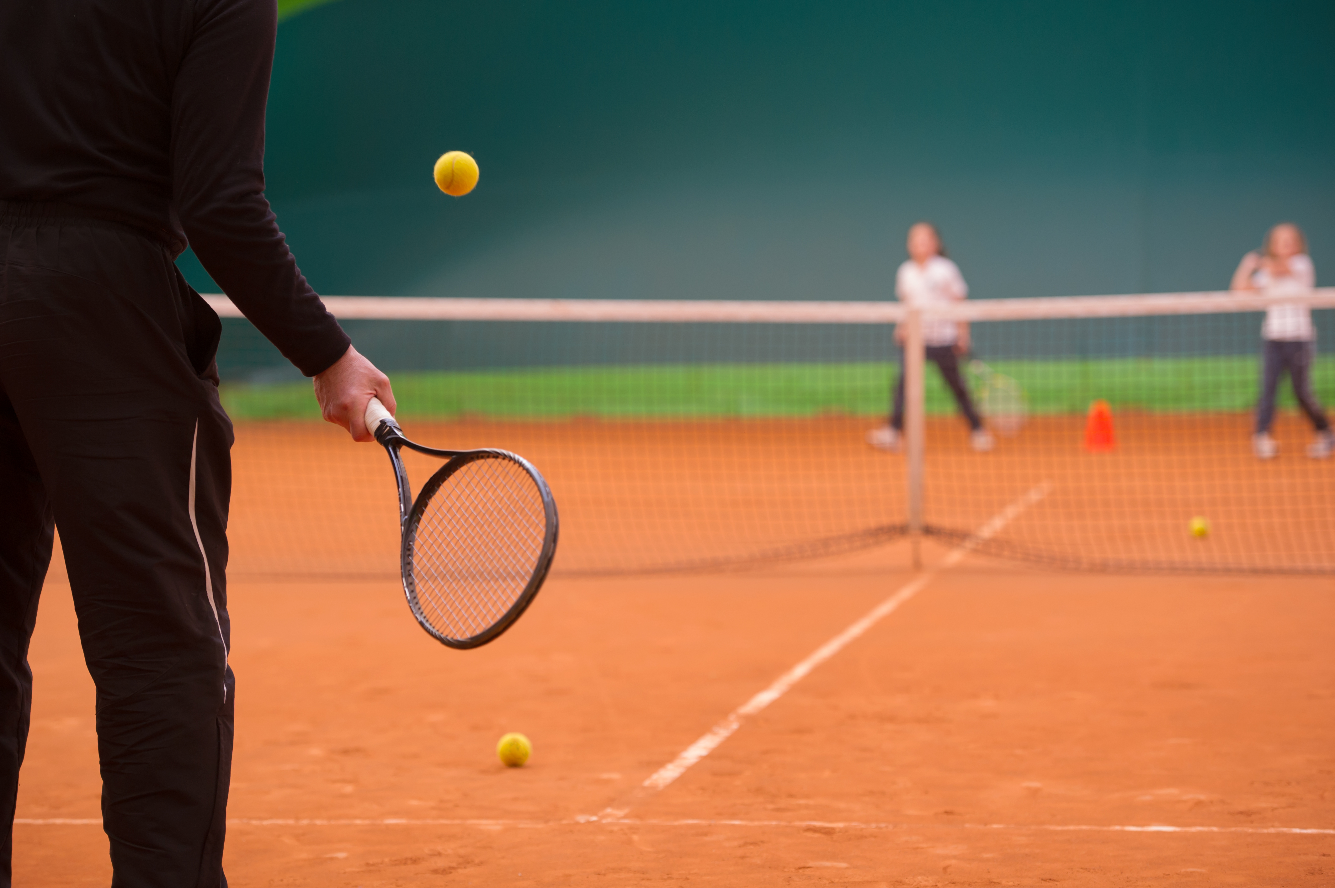 Mensen zijn aan het tennissen op een tennisveld bij Optisport.