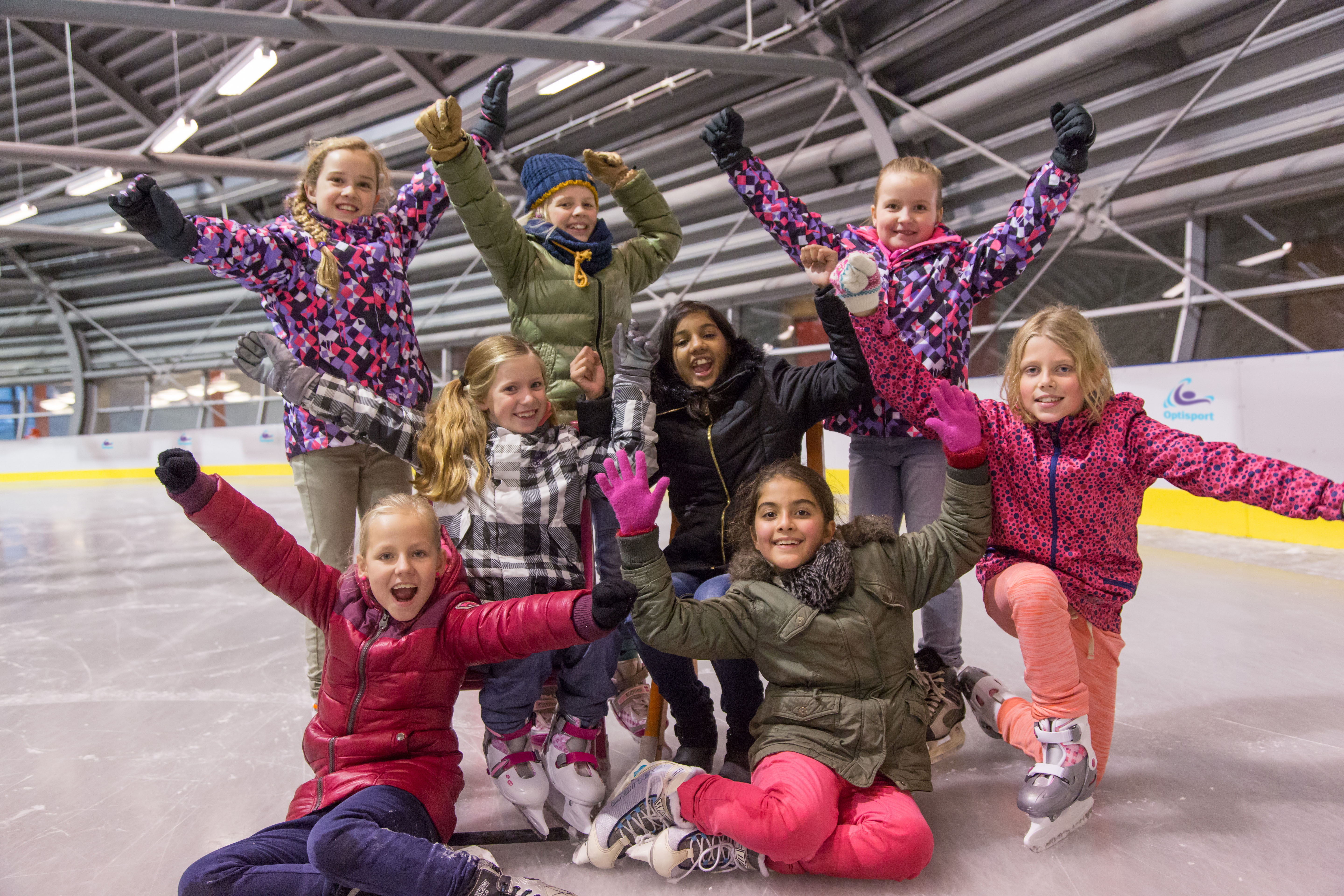 Kinderen zijn aan het schaatsen tijdens het schaatsfeestje.