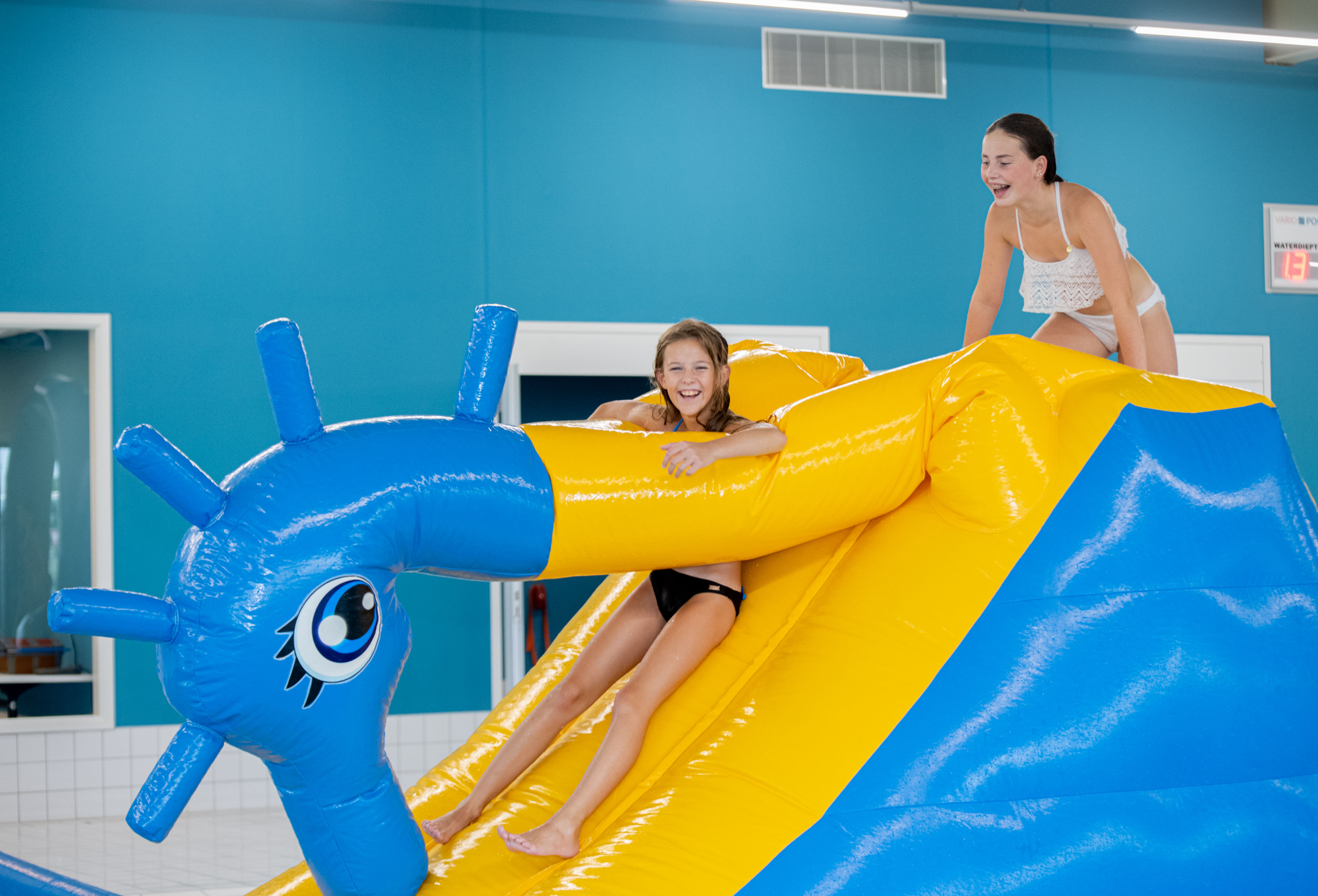 Kinderen hebben plezier op een opblaaskussen in een waterspeeltuin van Optisport.