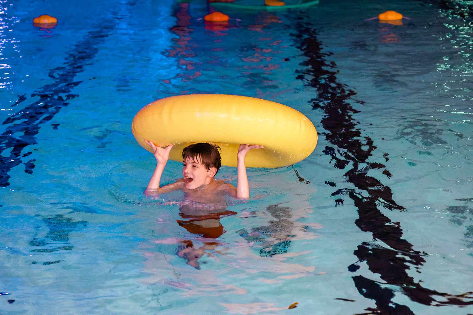 Een jongetje speelt met een zwemdonut in het zwembad van Optisport, tijdens een van de leuke activiteiten in het water. 