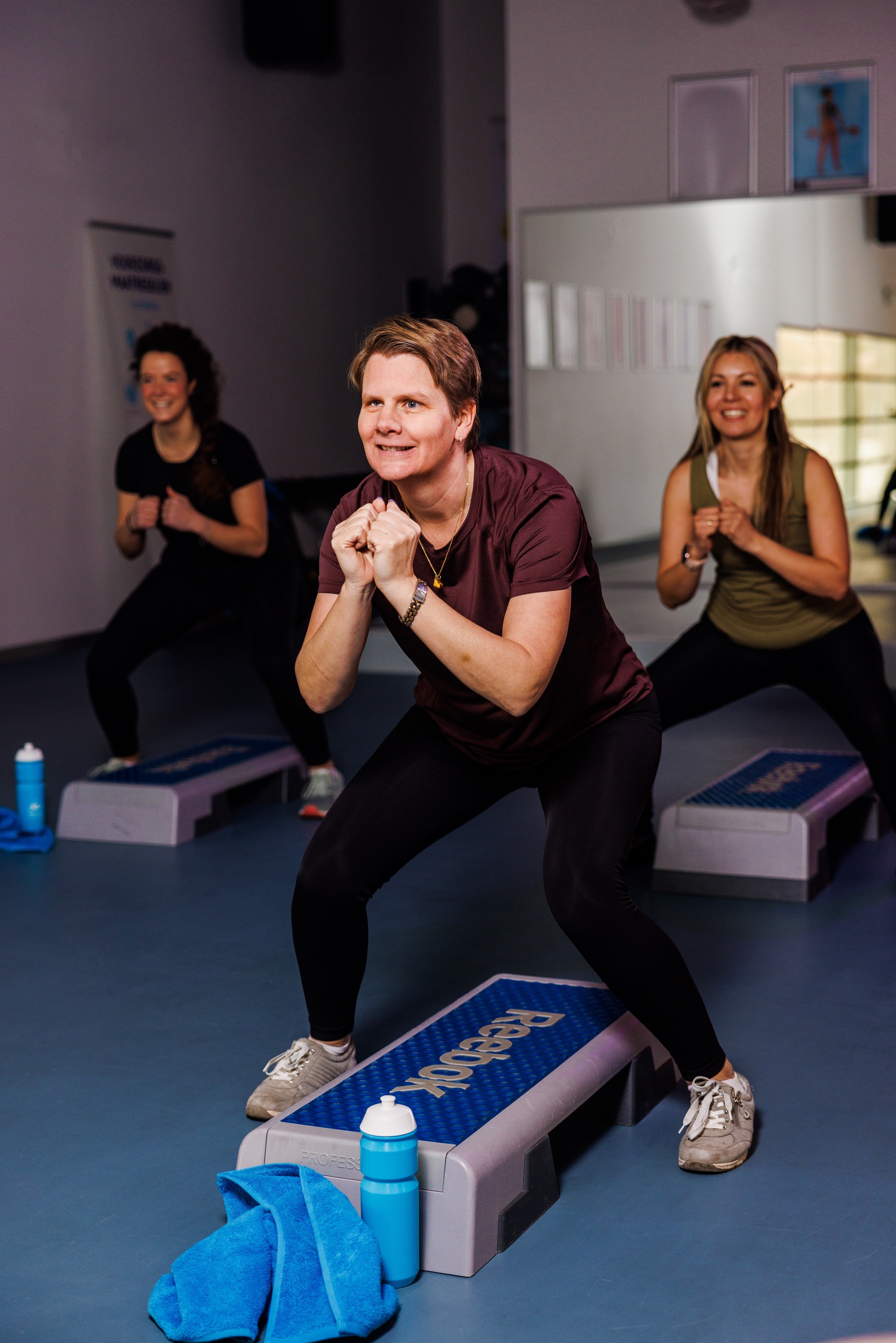 Sportende dames tijdens een les Club Step bij Optisport, onder leiding van een ervaren coach en gesteund door motiverende muziek trainen zij zodat ze veel vet verbranden. 