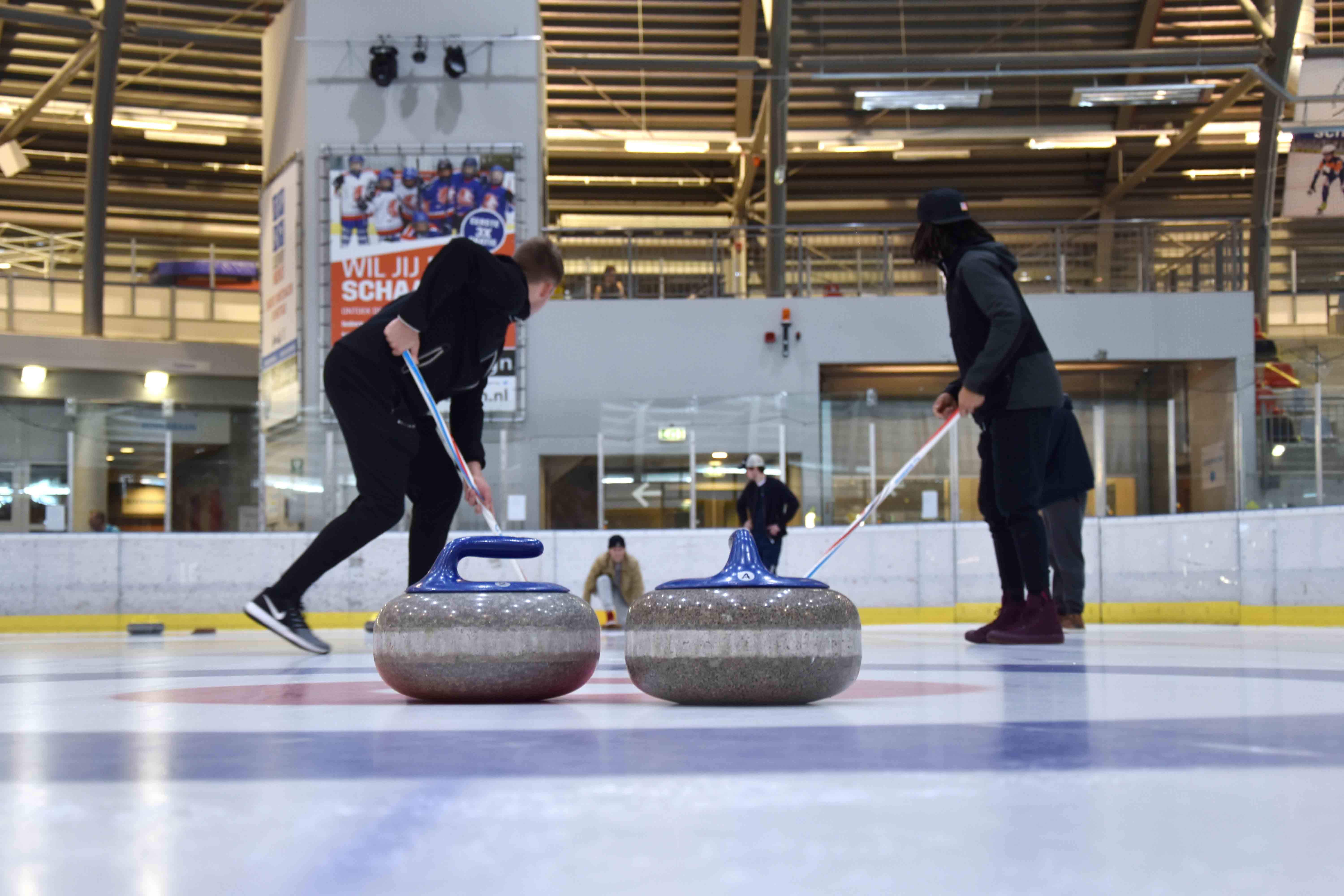 Vier mensen zijn bezig met een spel curling