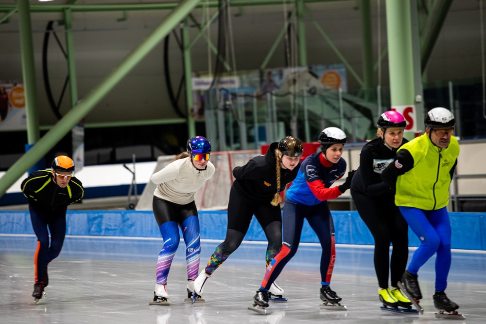 Een groep schaatst in een treintje rondjes tijdens het norenuur