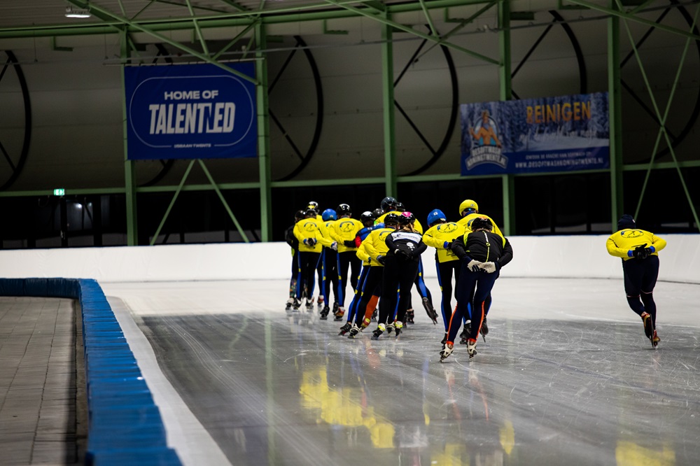 Een groep schaatst in een treintje rondjes tijdens het norenuur