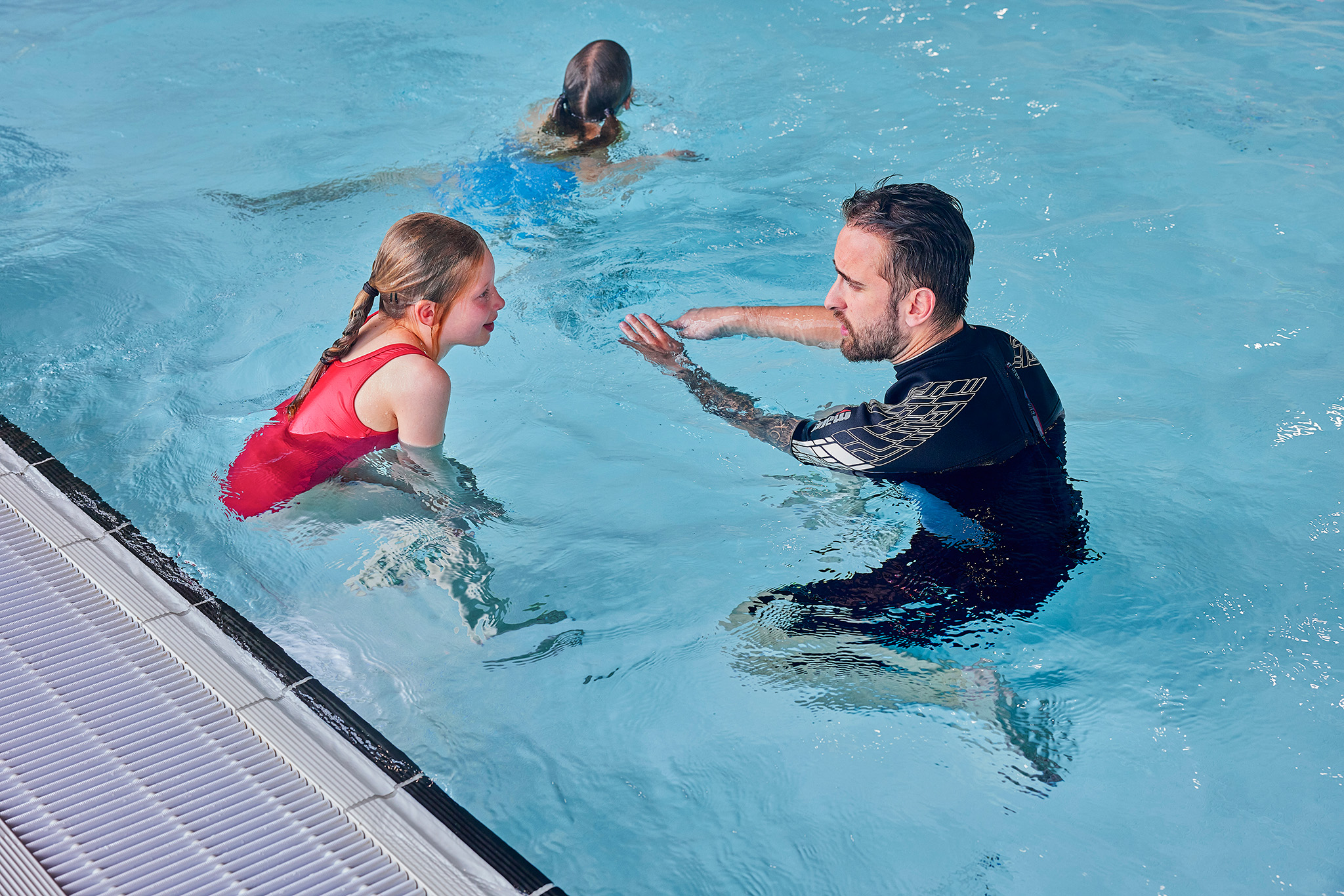 Een meisje krijgt privé instructies van een instructeur tijdens de Zed & Sop zwemlessen in het zwembad van Optisport. 