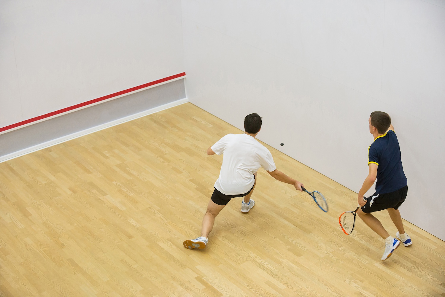 Twee mensen spelen squash bij Optisport.