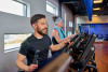 Man staat op een fitnessapparaat bij de sportschool samen met een vrouw