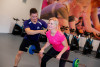 Fitness instructeur helpt dame met juiste houding